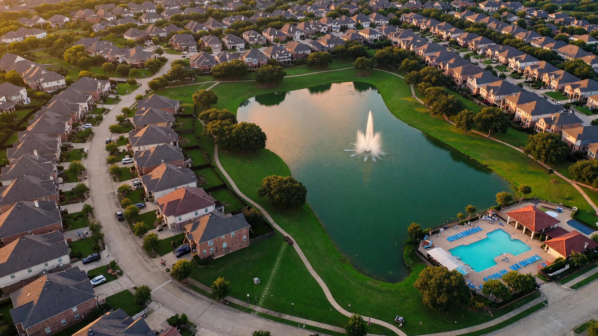 An aerial view of a Texas master-planned community with a central lake, the setting Sharcom clients call home