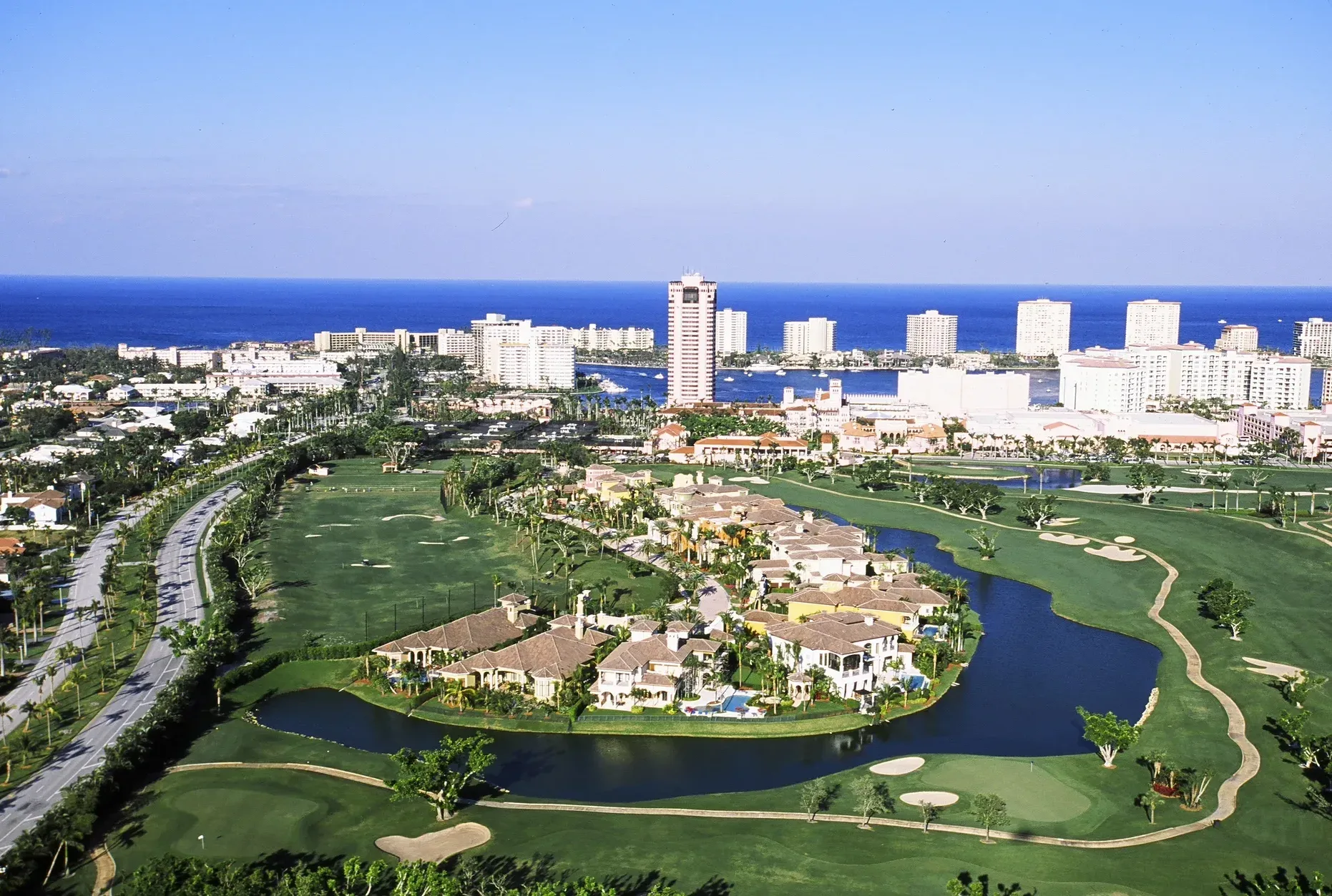Aerial view of Boca Raton luxury homes along a golf course with the coastal skyline and ocean beyond