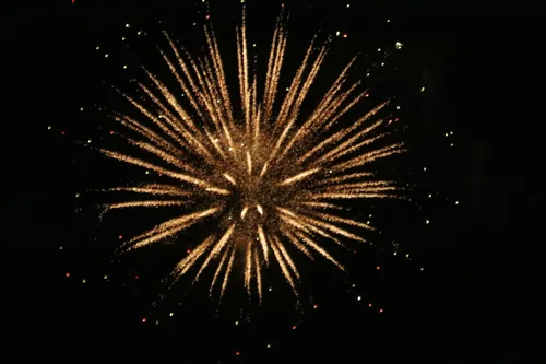 Golden aerial firework burst illuminating the night sky
