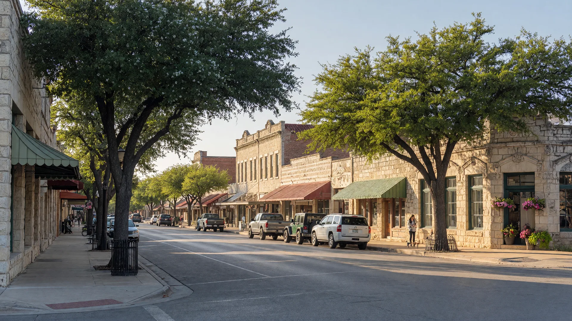 Historic downtown Boerne Texas with limestone storefronts and shade trees on a spring morning