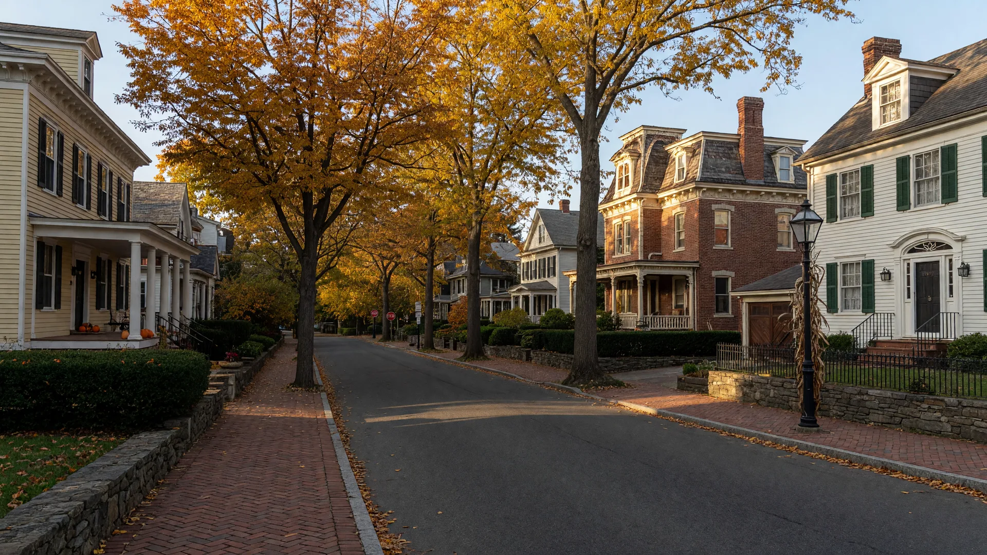 A quiet Moorestown-style residential street lined with historic colonial and Victorian homes and mature trees on an autumn afternoon