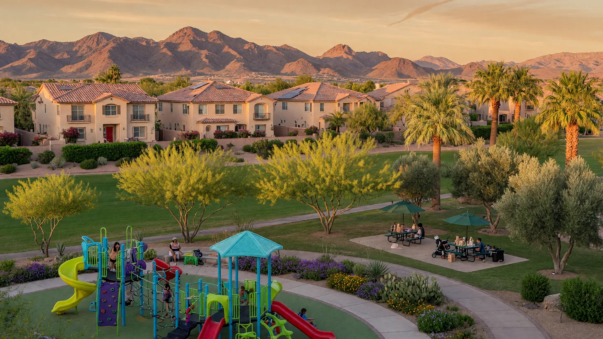 Landscaped neighborhood park with a playground and walking paths beside two-story stucco homes in a Las Vegas master-planned community