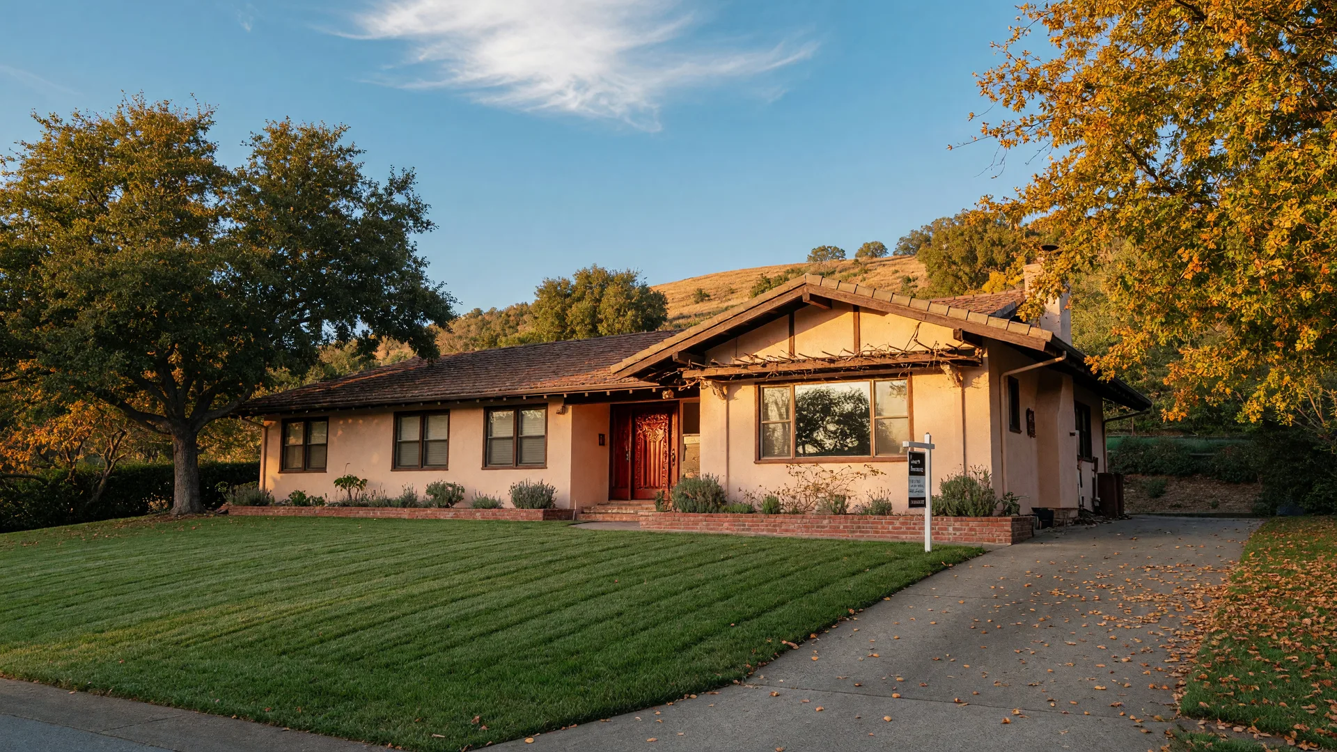 A California ranch-style home in the Castro Valley hills at golden hour with a for-sale sign by the driveway