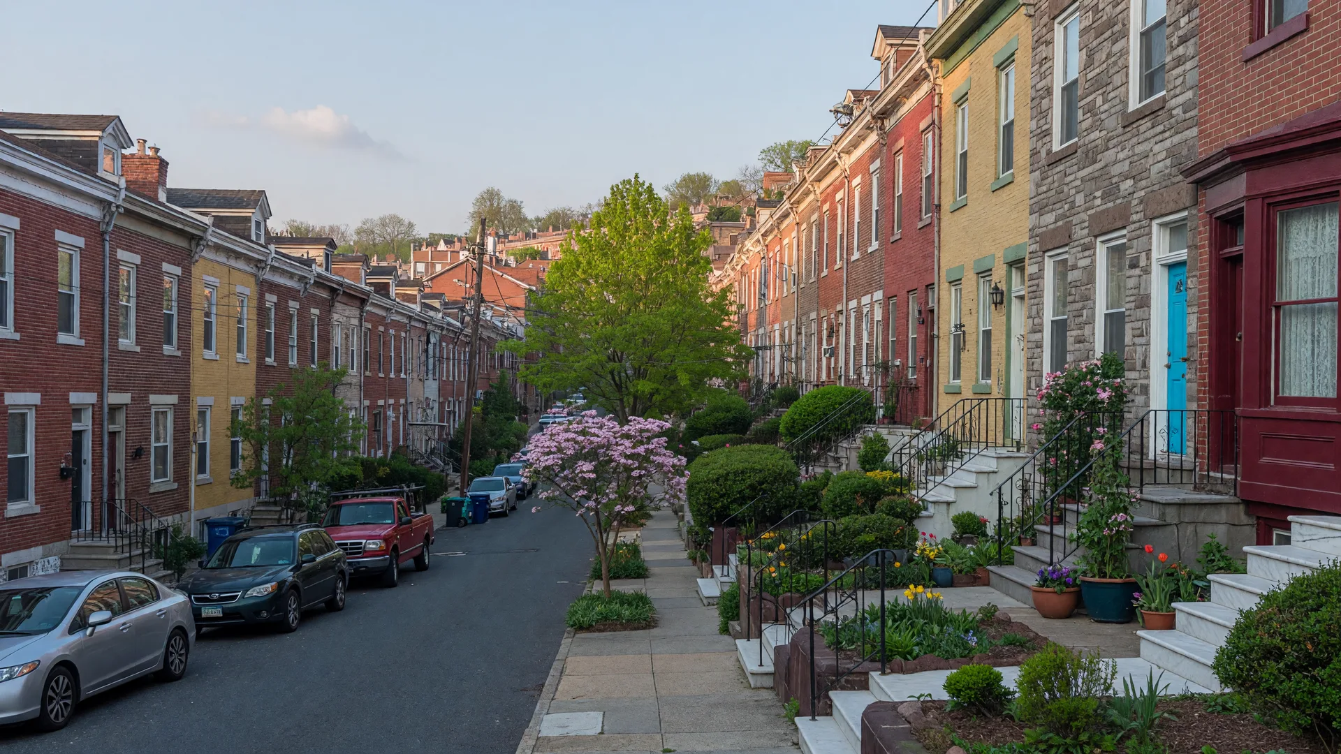 Hillside rowhomes on a steep Manayunk street with colorful brick and stone facades