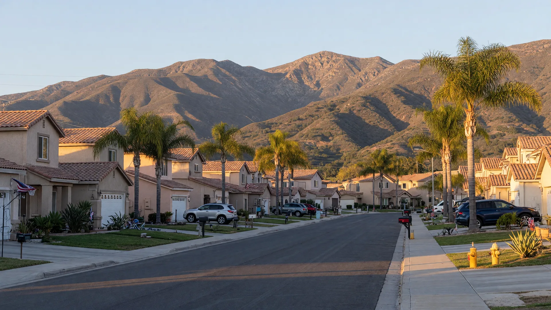 Moreno Valley residential street with newer stucco homes, palm trees, and the Box Springs Mountains rising in the background