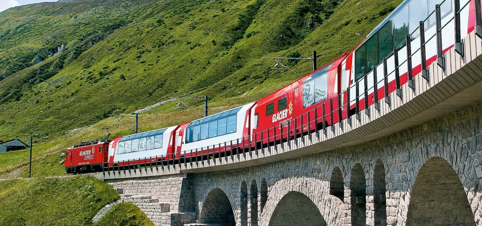 El tren panorámico Glacier Express cruzando un viaducto en los Alpes suizos