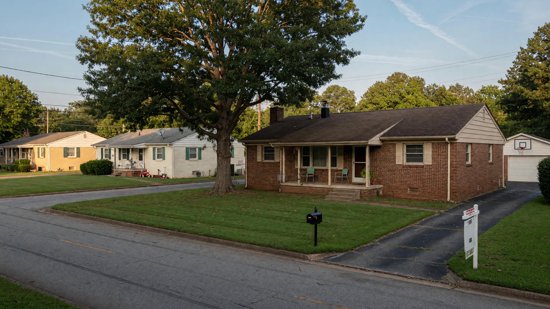 A modest brick-and-siding ranch home with a front porch and a For Sale sign in a tree-lined suburban Metro Atlanta neighborhood, representing what a $400,000 budget buys