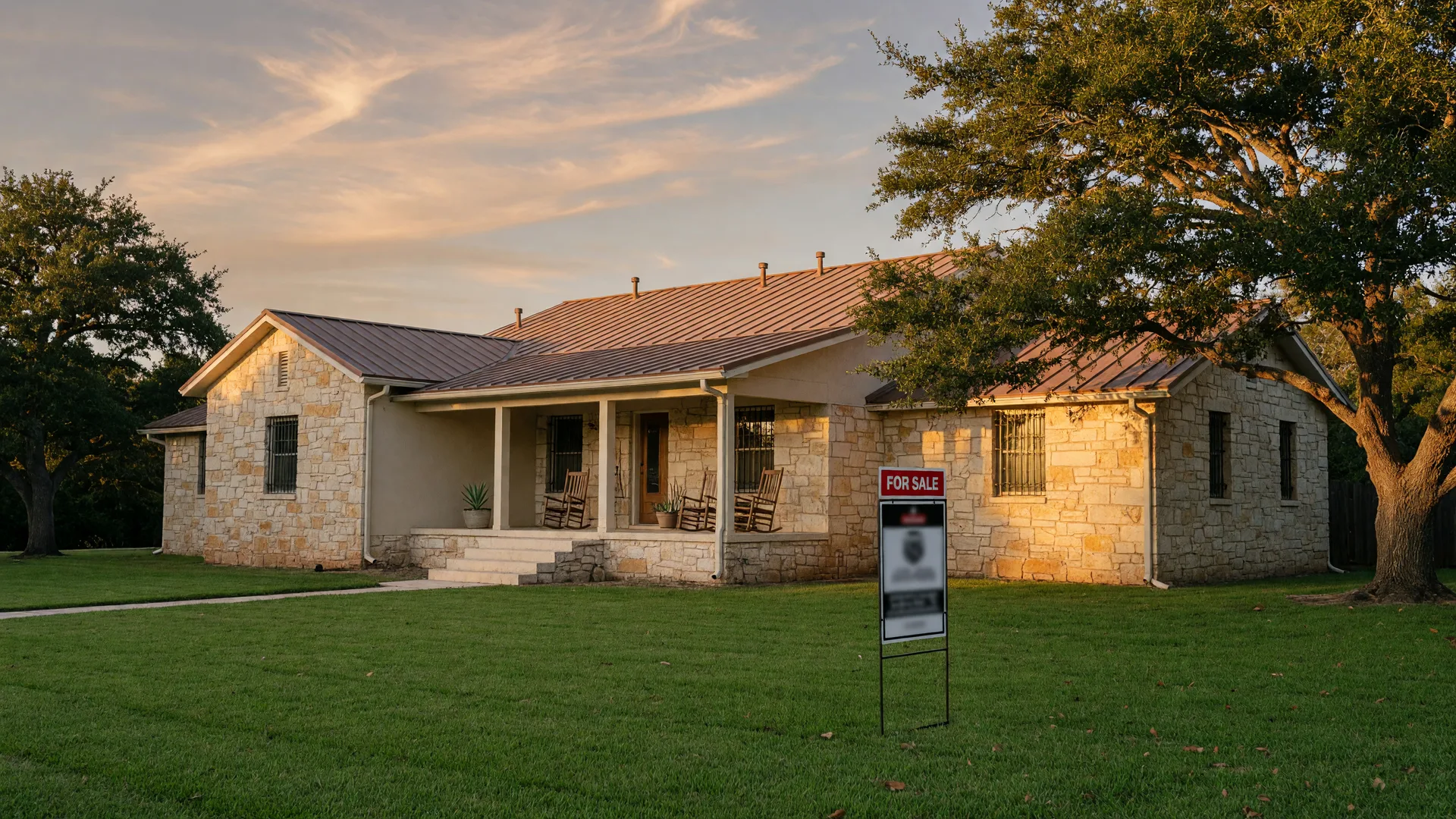 A well-kept Texas Hill Country stone home with a for-sale sign in the front yard in warm late-afternoon light