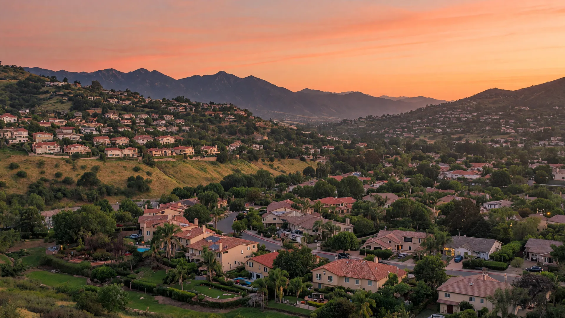 Santa Clarita Valley hillside neighborhoods at golden hour with the San Gabriel Mountains in the distance