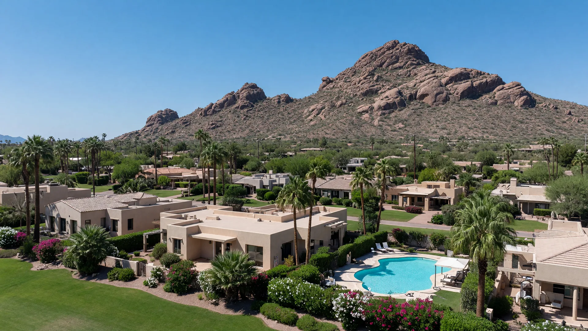 Golden hour view of Scottsdale, Arizona, with Camelback Mountain glowing behind palm-lined resort neighborhoods