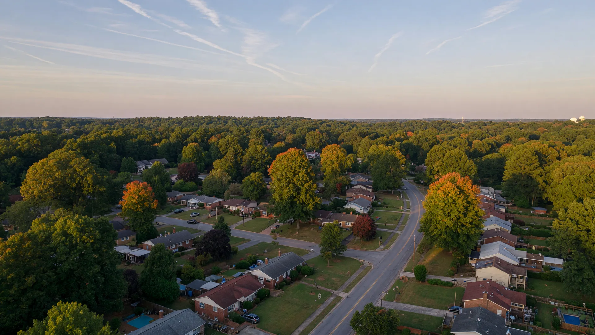 Aerial view of a leafy Atlanta suburban neighborhood in early autumn light