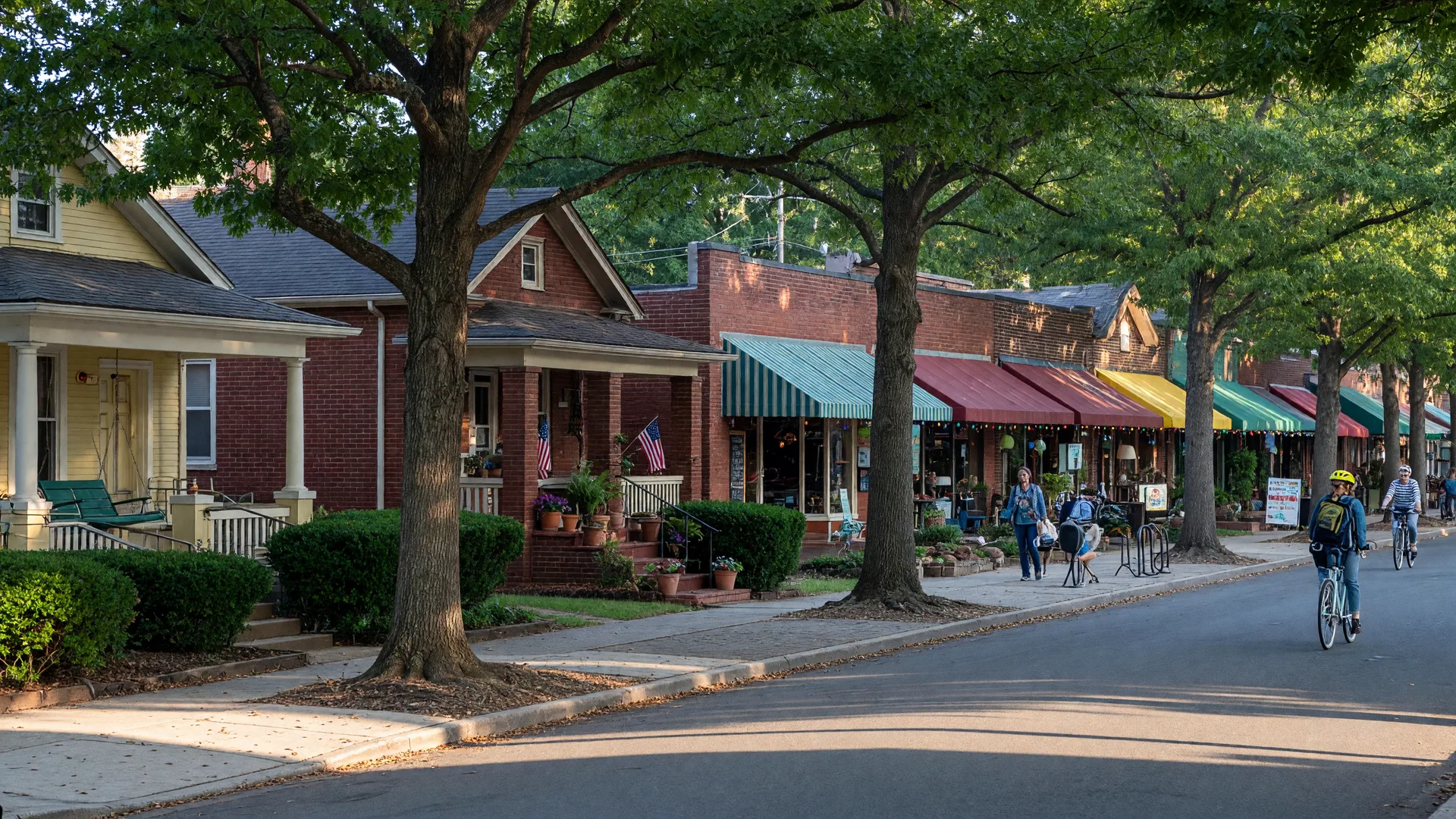 Plaza Midwood Charlotte along Central Avenue with brick bungalows, awninged local shops and cafes, and tree-dappled sidewalks in morning light