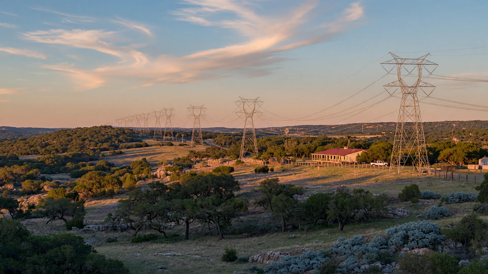 Texas Hill Country landscape with power transmission lines stretching across rolling hills at golden hour