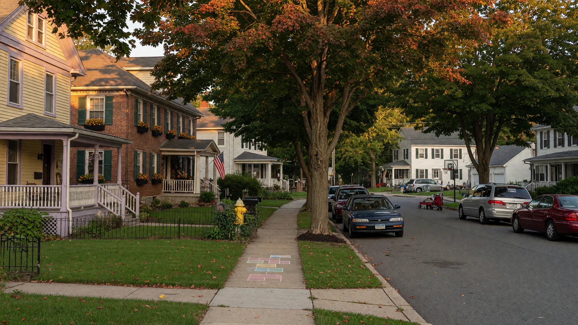 Quiet residential street in Yeadon, Pennsylvania with Colonial and Victorian-style homes under warm late-summer afternoon light