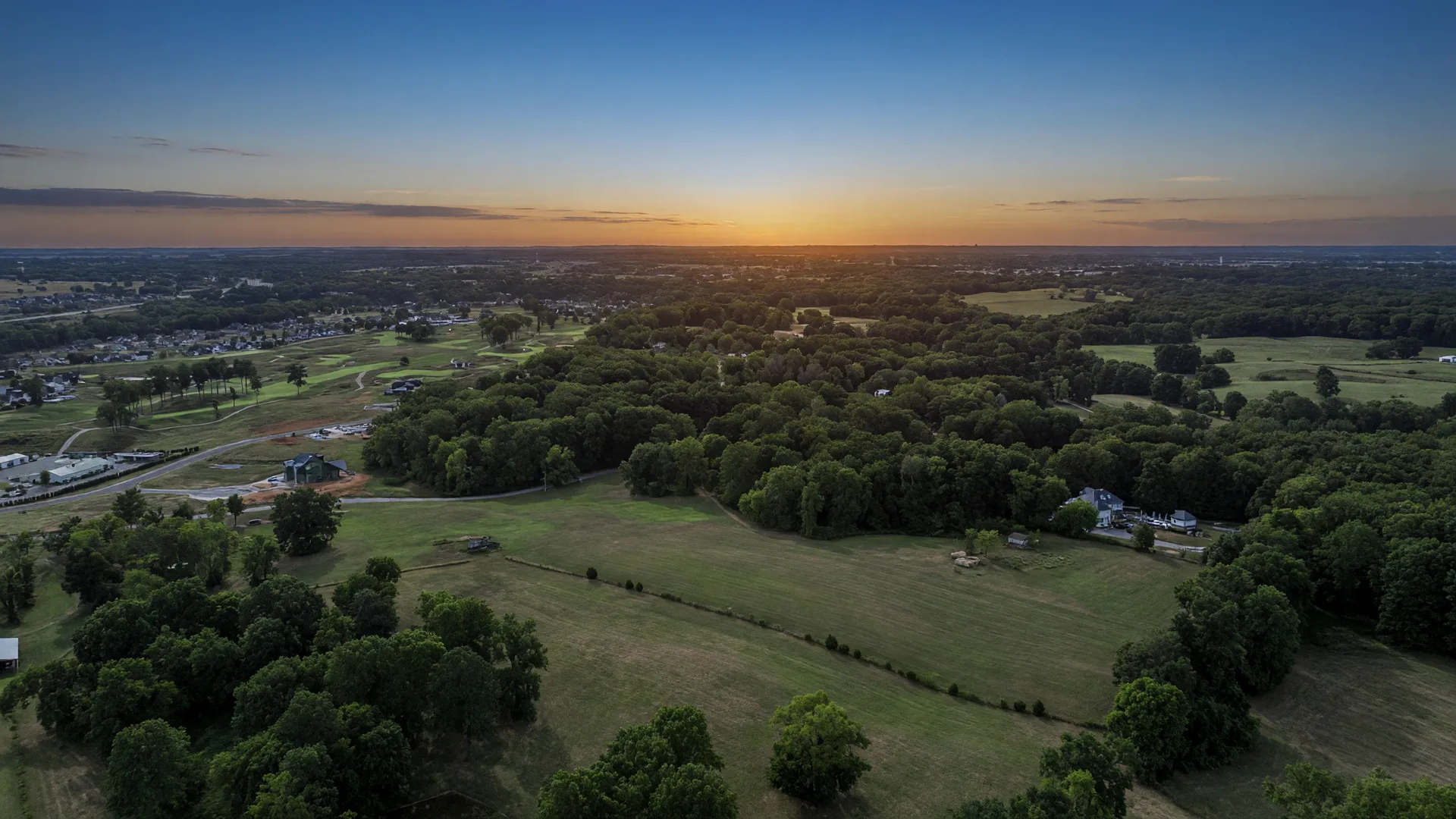 Aerial view of 3860 Old Scottsville Rd at dusk, rolling fields and tree lines under a blue-gold sky