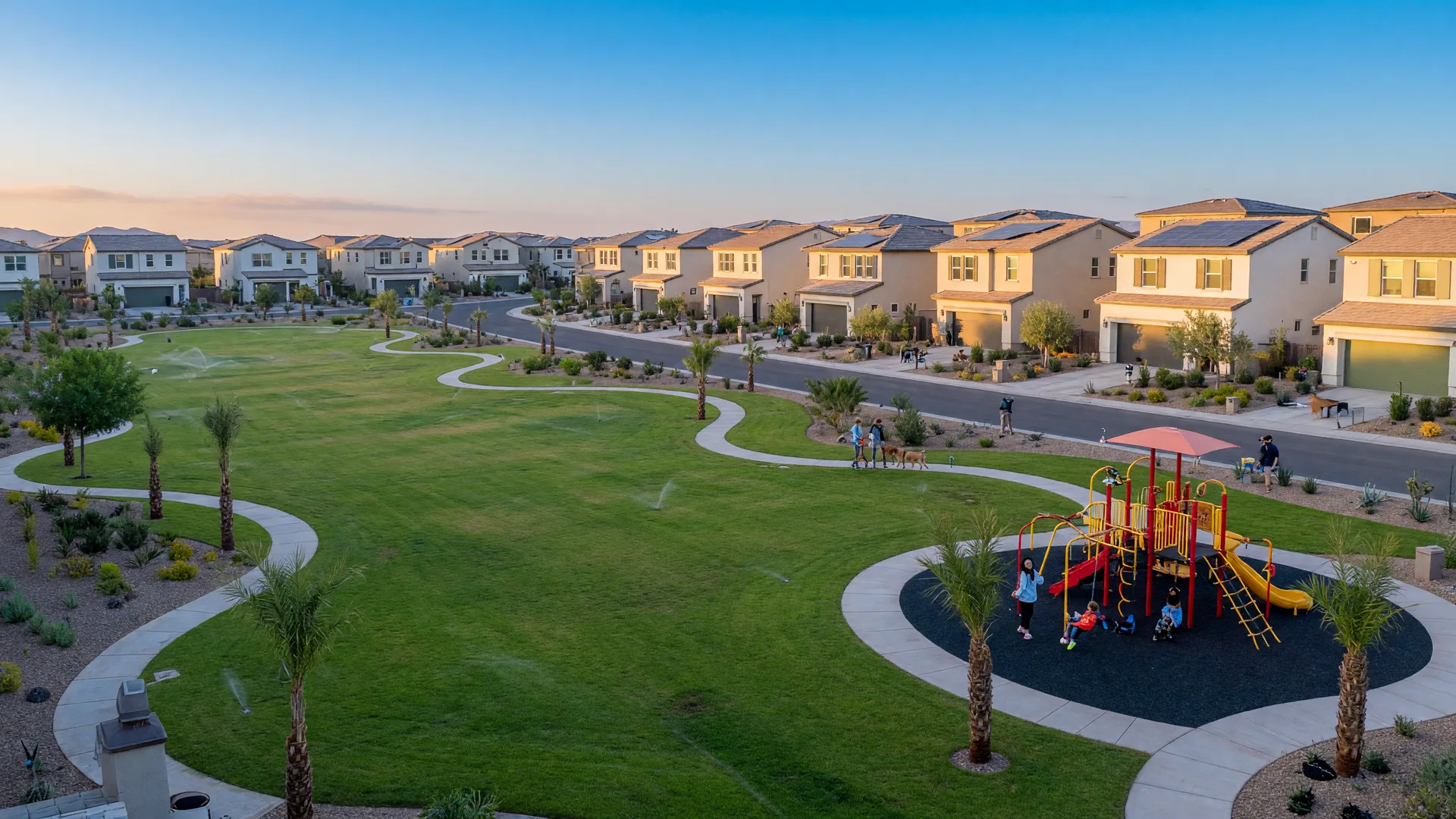 Modern single-family homes in a new family village with a large green central park with walking paths and a playground in Henderson in the morning
