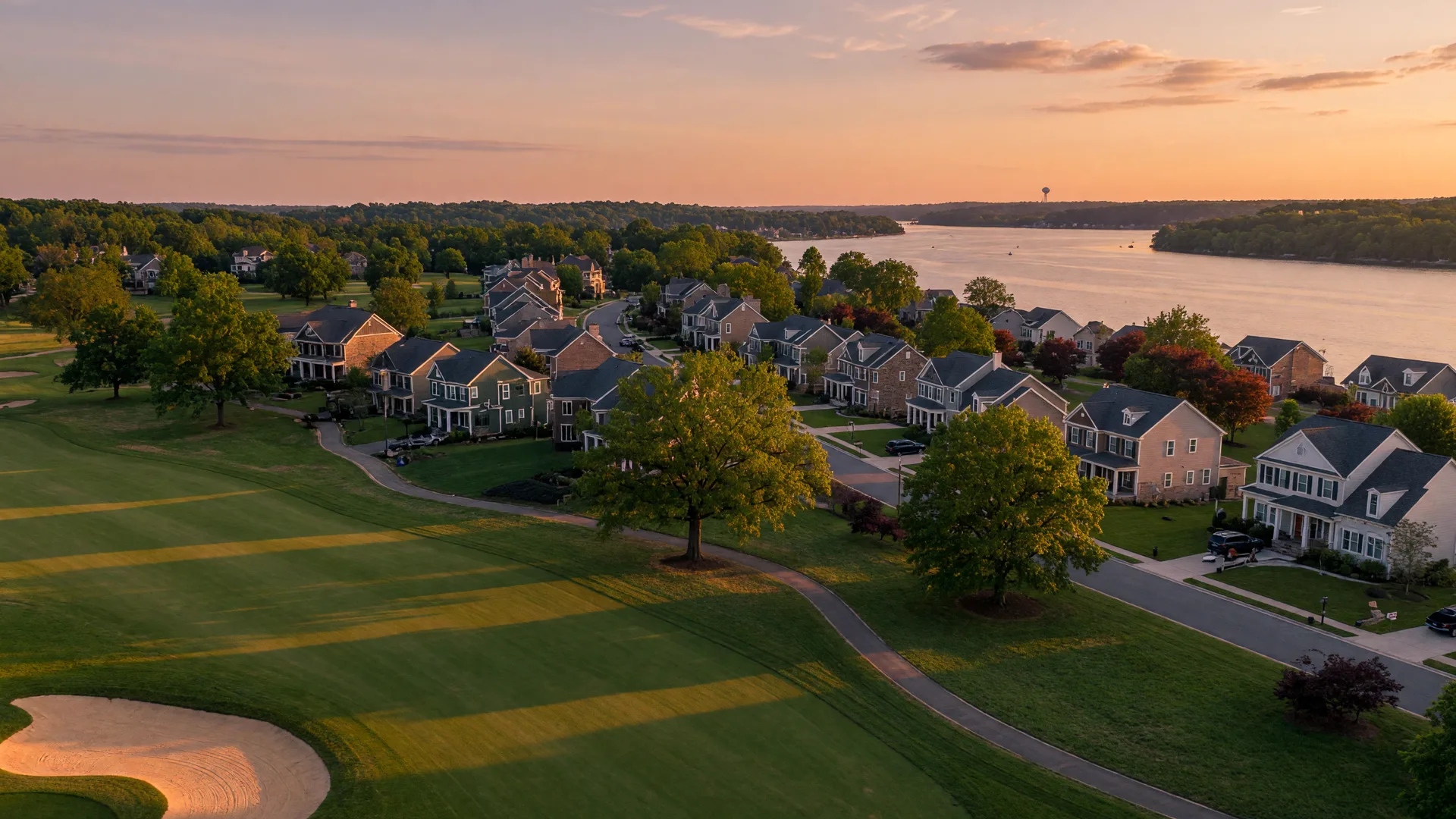 New craftsman and colonial single-family homes on tree-lined streets beside a golf course in the Potomac Shores master-planned community in Prince William County, Virginia