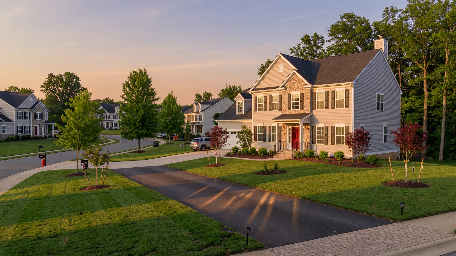 Newly built colonial-style home in a Stafford County, Virginia community at golden hour with manicured lawn and warm evening light