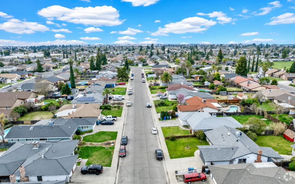 Quiet residential street in Winton, California with single-family homes and open farmland views