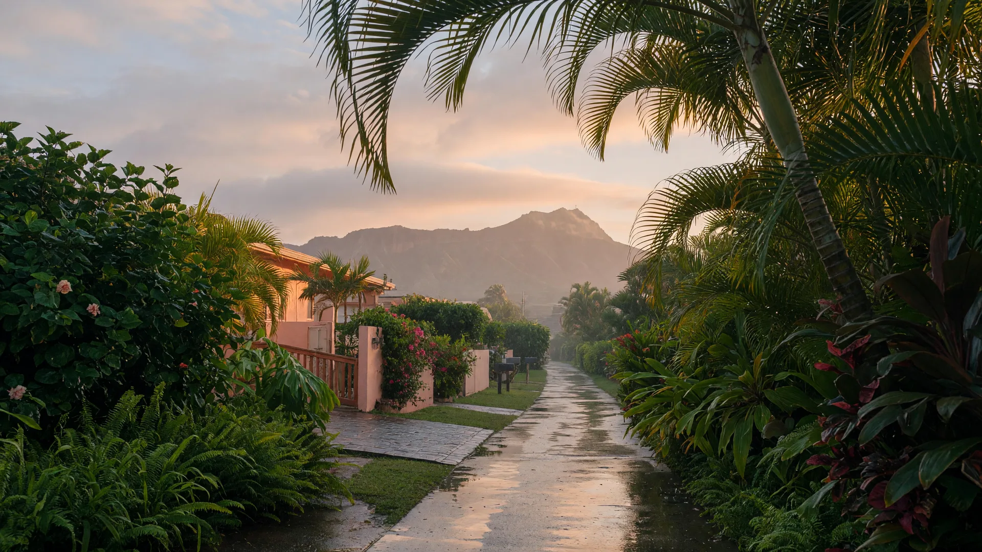 A quiet Honolulu neighborhood morning with trade-wind clouds drifting over Diamond Head in the distance and a rain-dampened path in the foreground