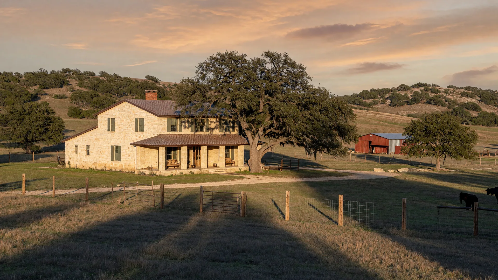 Texas Hill Country ranch homestead near Boerne with limestone house and live oaks at golden hour