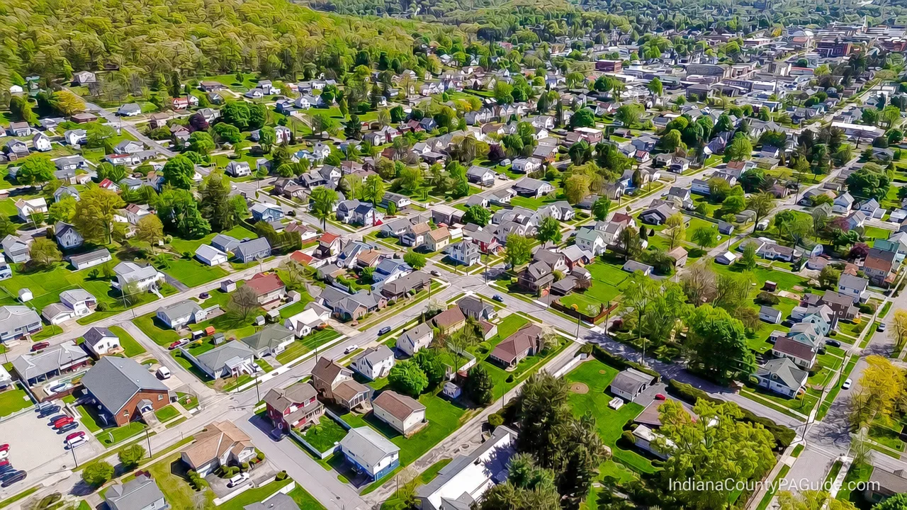 Aerial view of Indiana, PA showing tree-lined residential streets and green hills