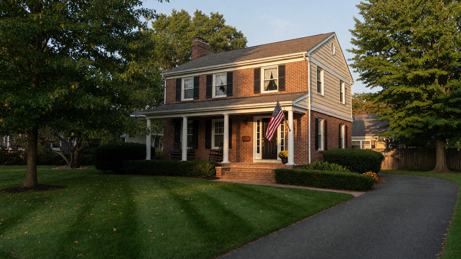 Welcoming colonial-style home in South Jersey with a neatly kept front porch and an American flag on a clear morning