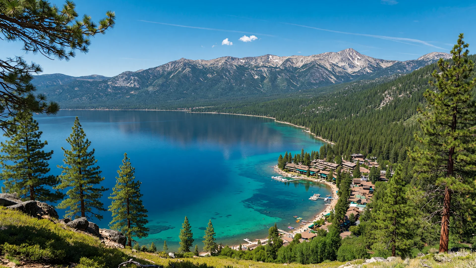 Lake Tahoe from the Nevada side with deep blue water, pine trees, and surrounding mountains