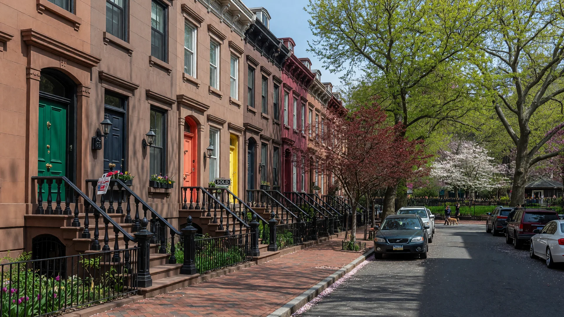 Historic brownstones with For Sale signs on a tree-lined street in Fitler Square, Center City Philadelphia