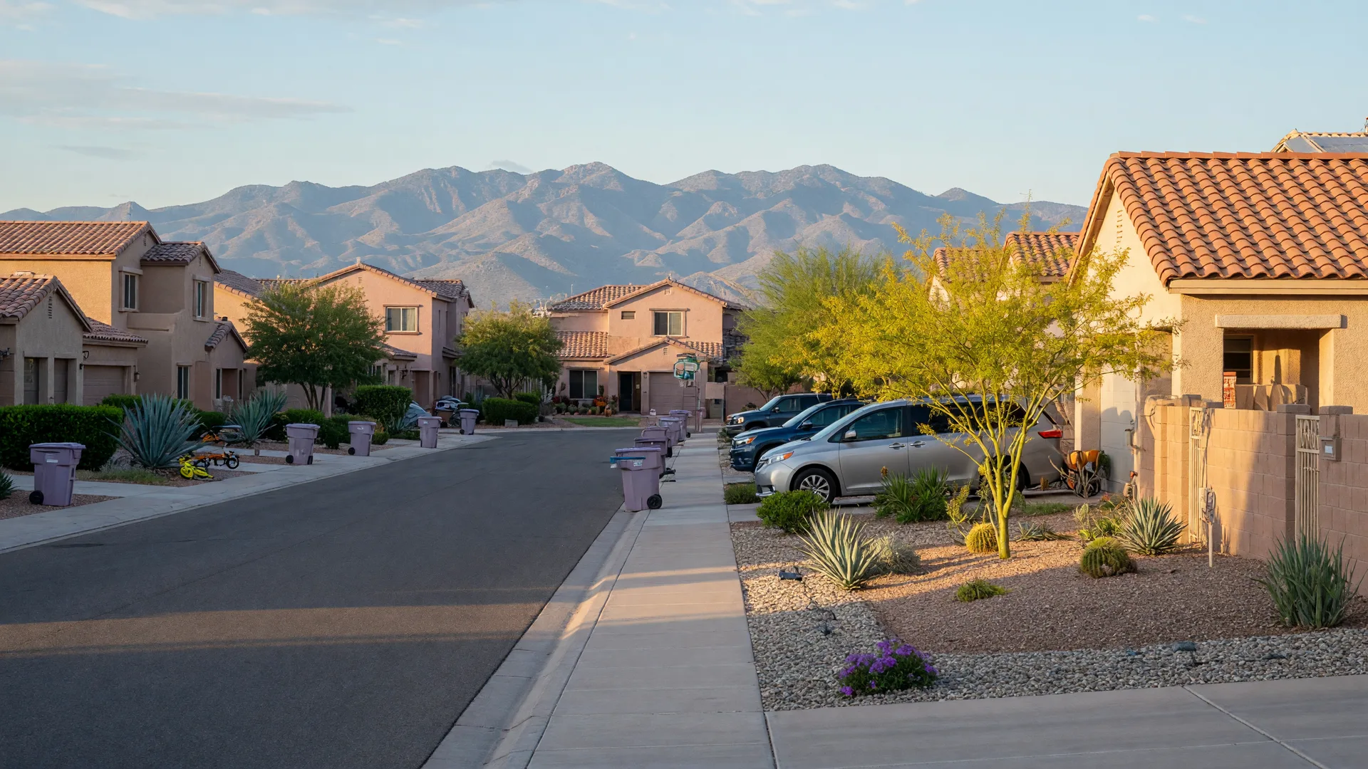 A quiet residential street in Gilbert, Arizona on a clear late September morning with modern Southwestern homes, desert landscaping, and the San Tan Mountains on the horizon