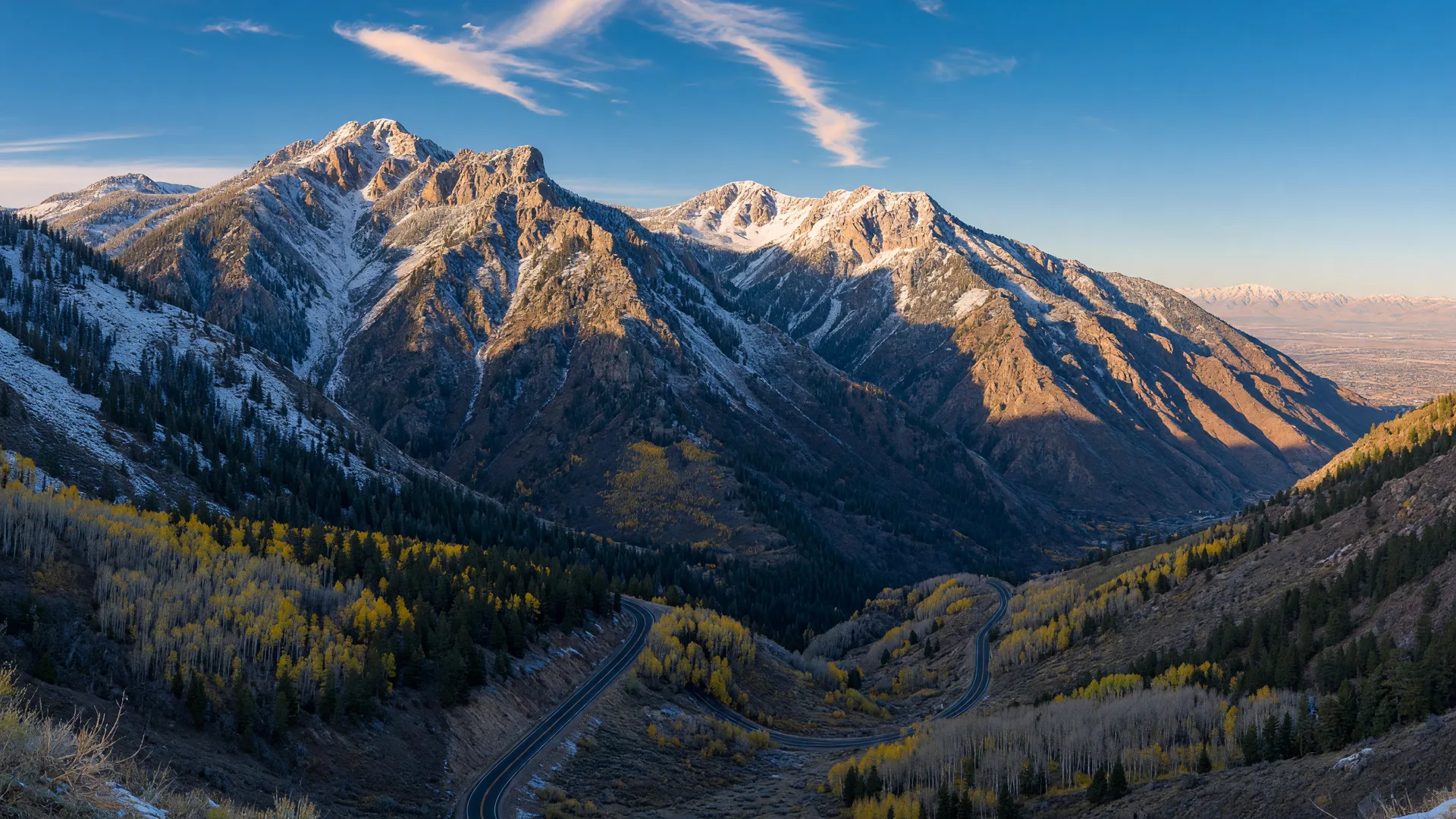 The Wasatch Mountains under the first dusting of early-season snow with golden light on the peaks