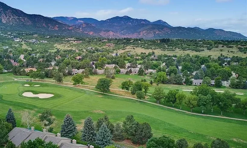 Aerial drone view of the golf course fairways and the Cheyenne Mountain backdrop at the Woodbridge community