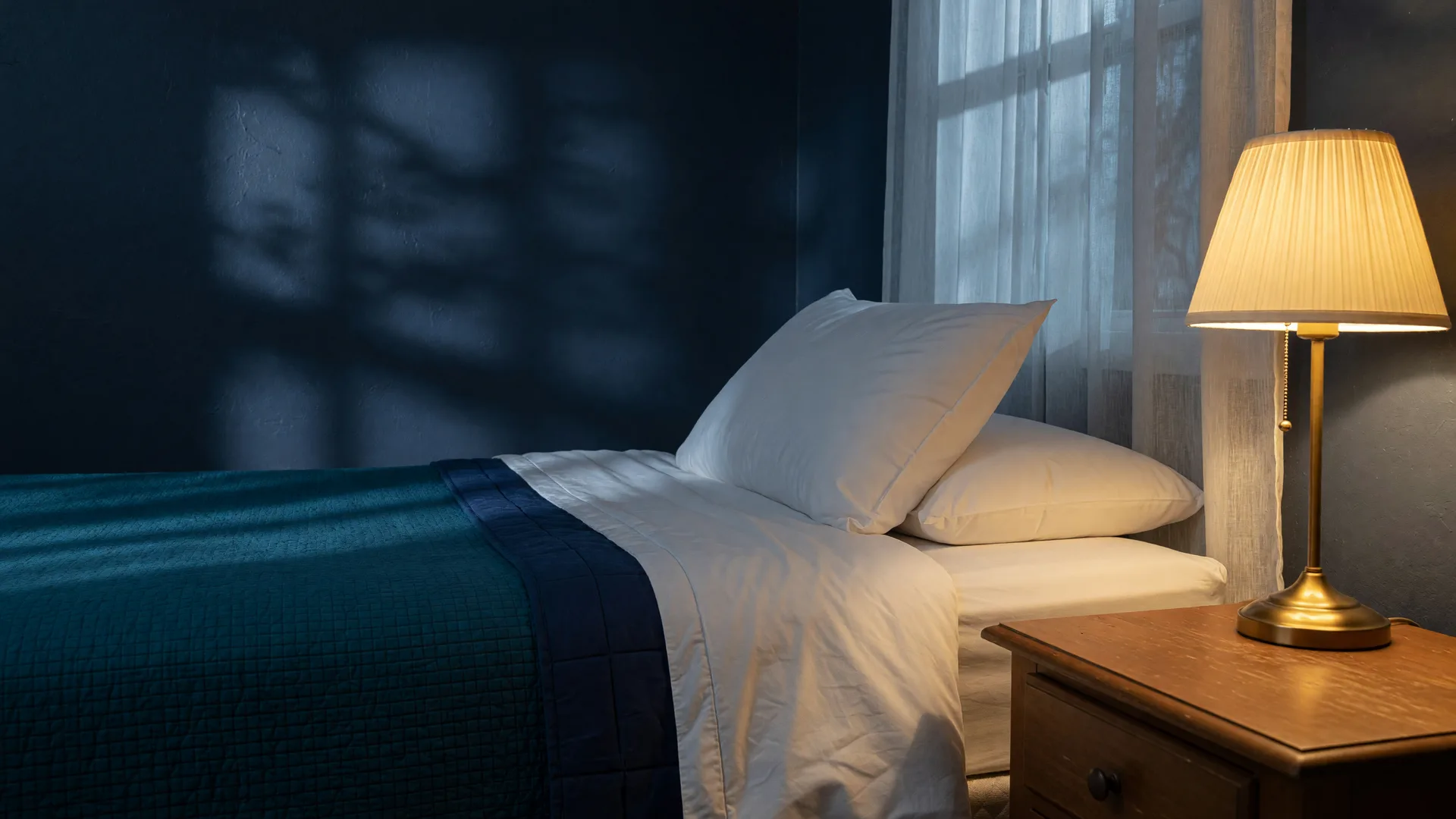 A serene, peaceful bedroom with teal bedding and soft lamplight, representing the goal of healthy, restful sleep