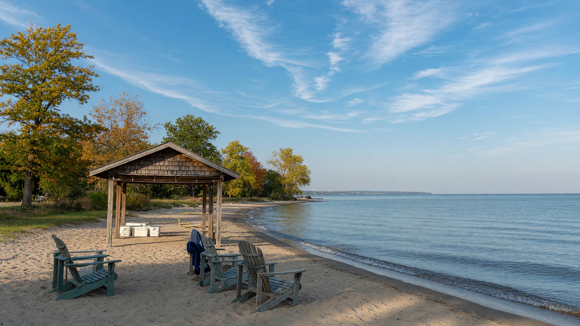 A sandy Lake Erie beach with chairs and a beach club pavilion in autumn
