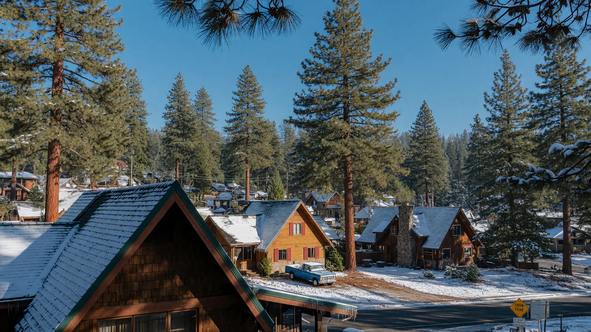 Snow-dusted chalet homes among tall Ponderosa pines in Pollock Pines, California