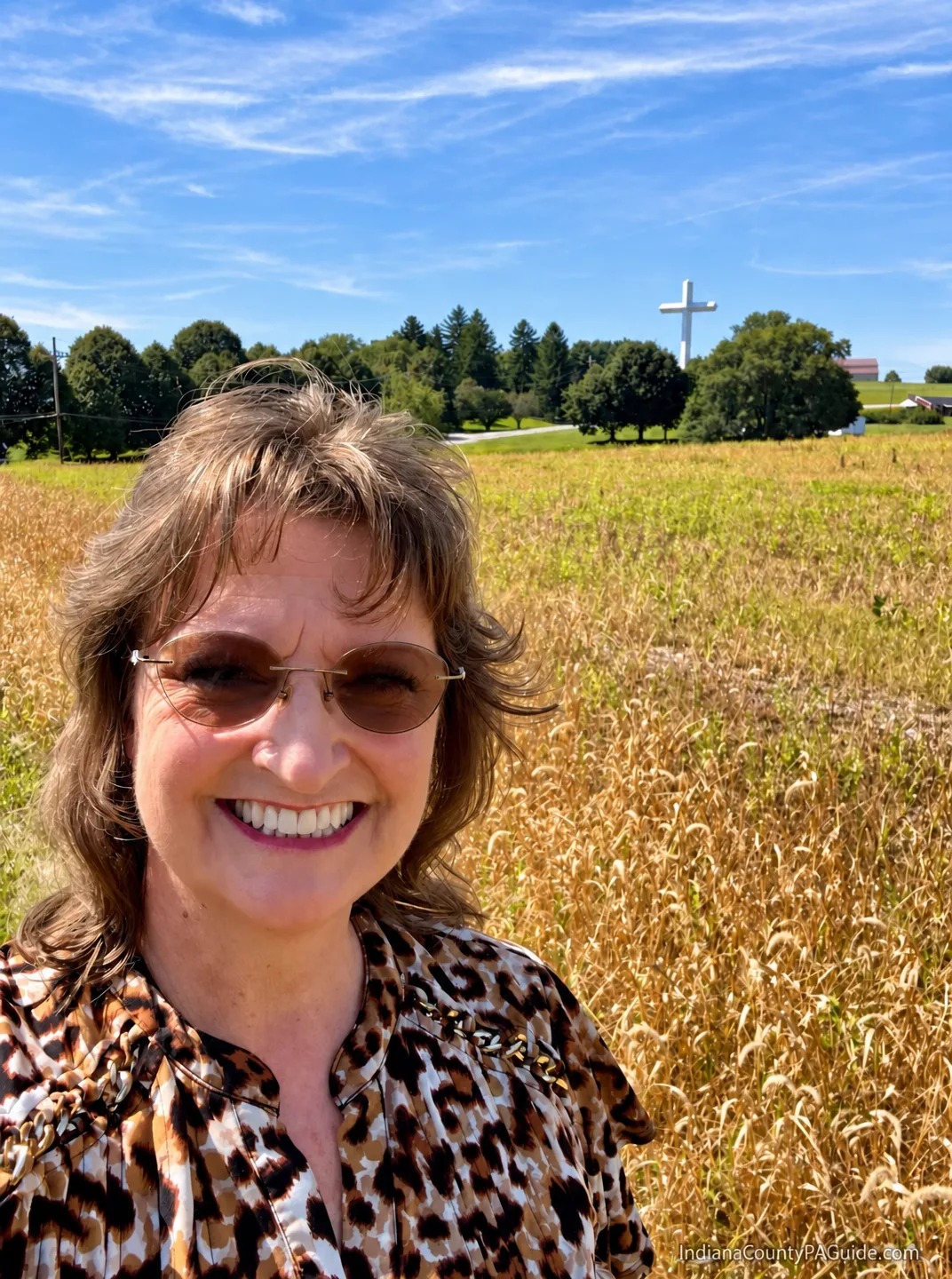 Sheri Kunkle standing at the base of the 108-foot cross at Hilltop Baptist Church in Indiana County, PA