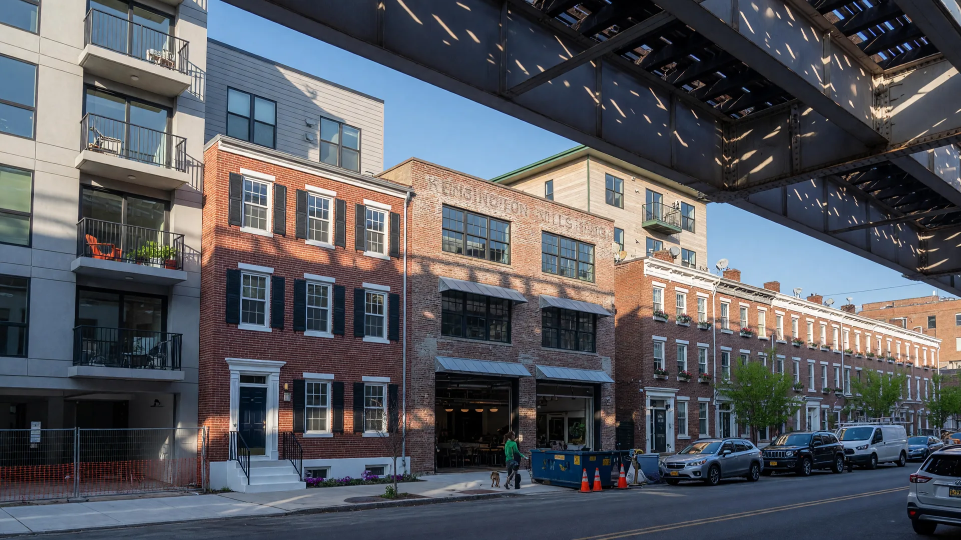Fishtown real estate along Front Street showing new construction condos, renovated brick rowhomes, and the elevated SEPTA Market-Frankford Line on a bright morning
