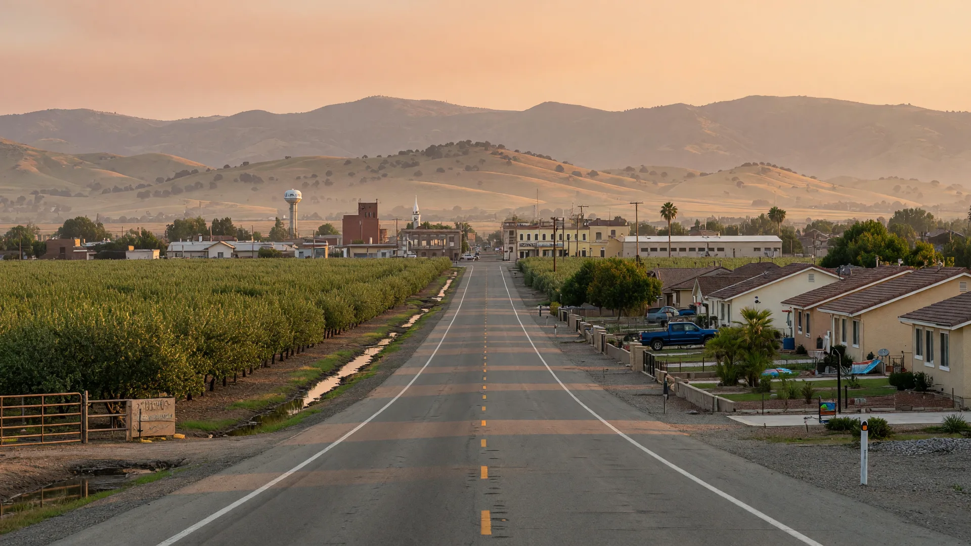 A country road near Madera with farmland and homes under the Sierra foothills