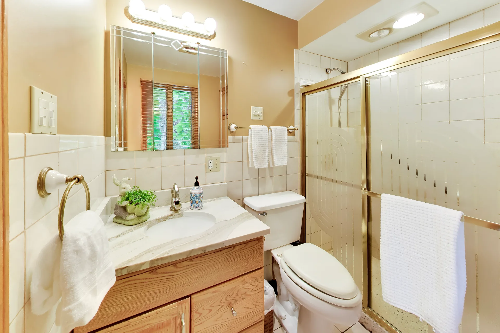 Bathroom with wood vanity and tiled walls