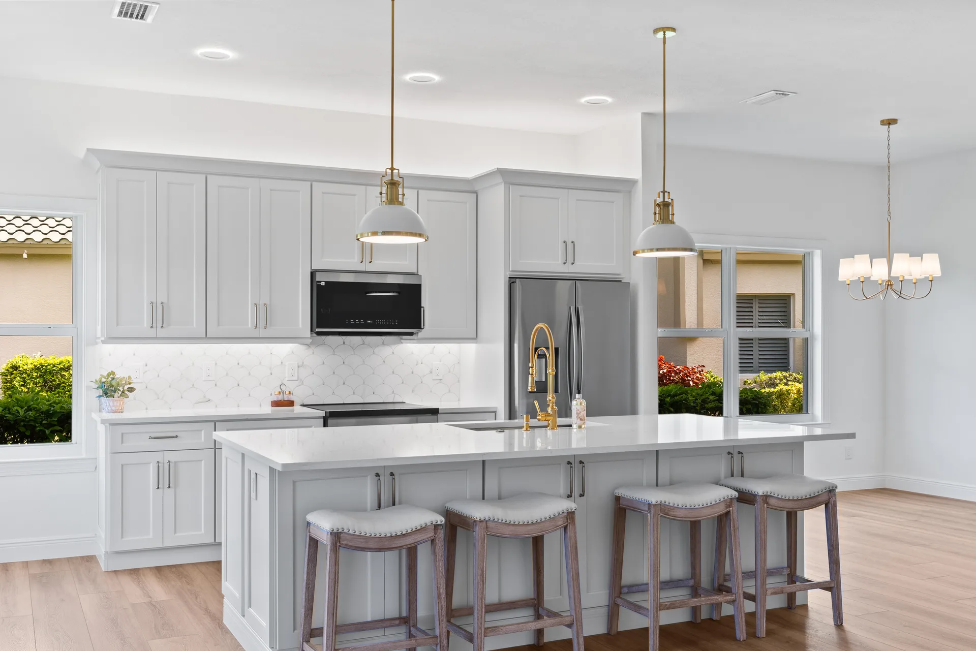 Open-concept kitchen with stainless steel appliances and brass hardware