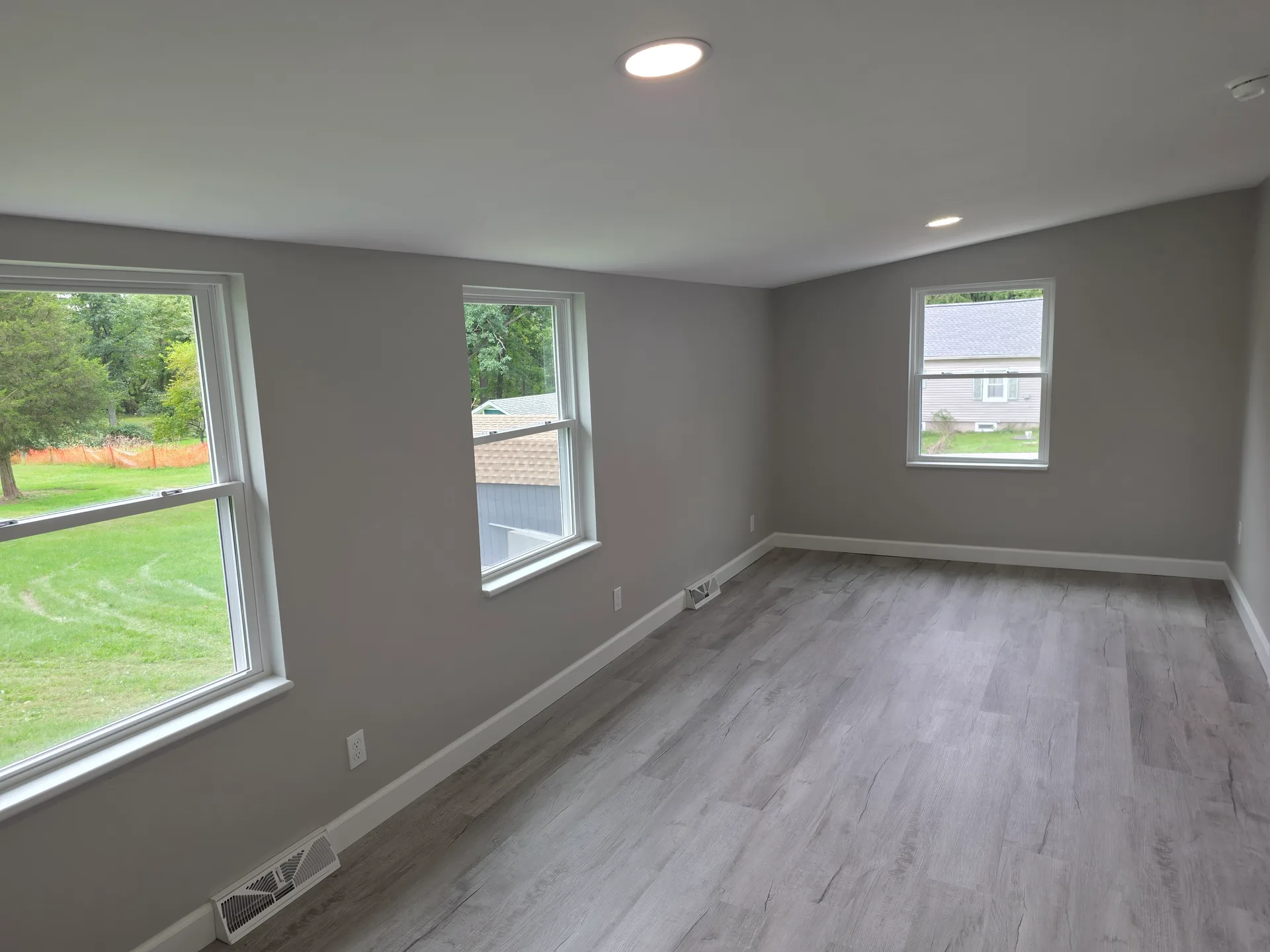 Bedroom or living space with slanted ceiling and three windows