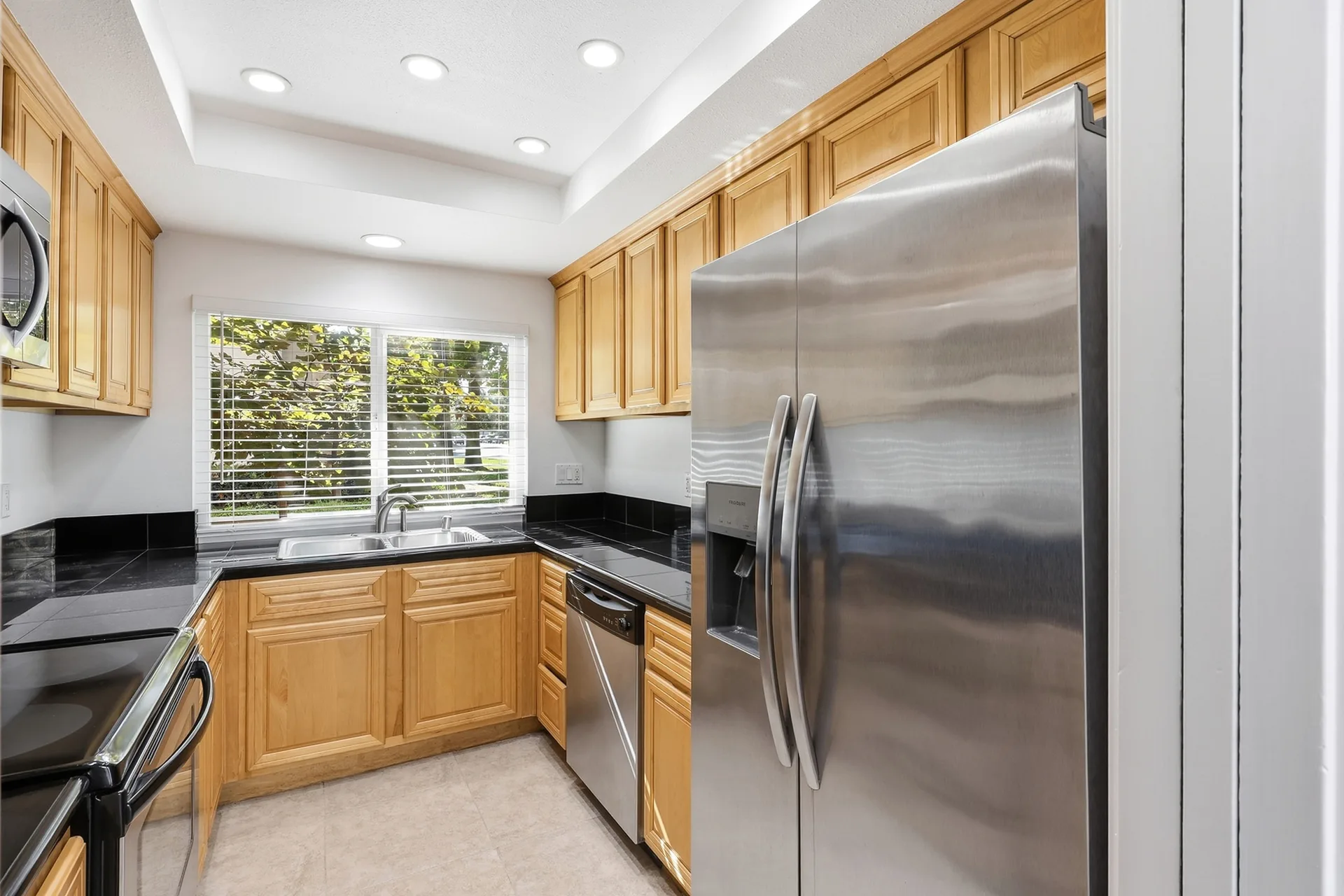 Kitchen at 8 Silverwood with wood cabinetry, black countertops, and stainless steel appliances