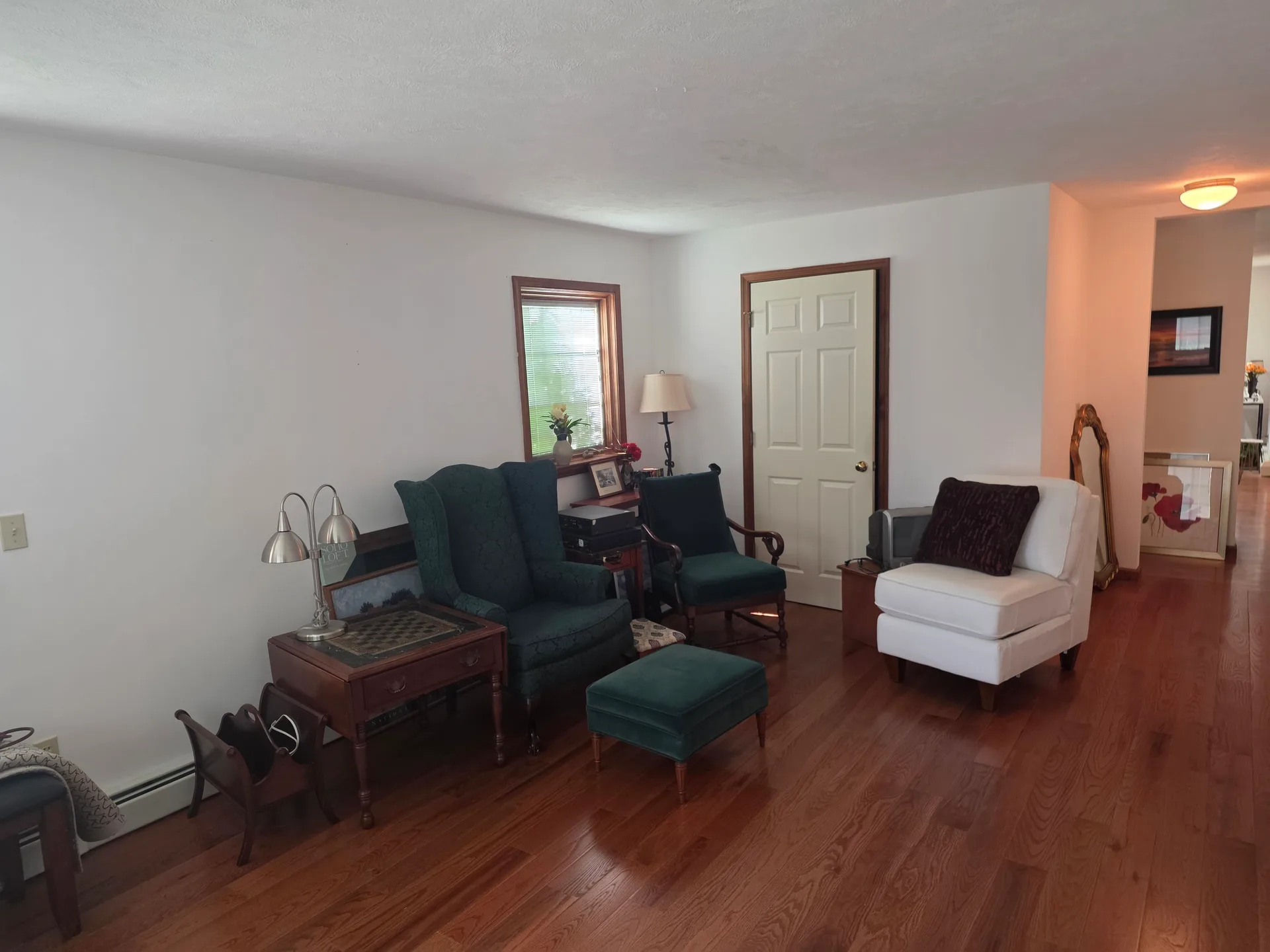Living room with natural daylight from large window and hardwood floors