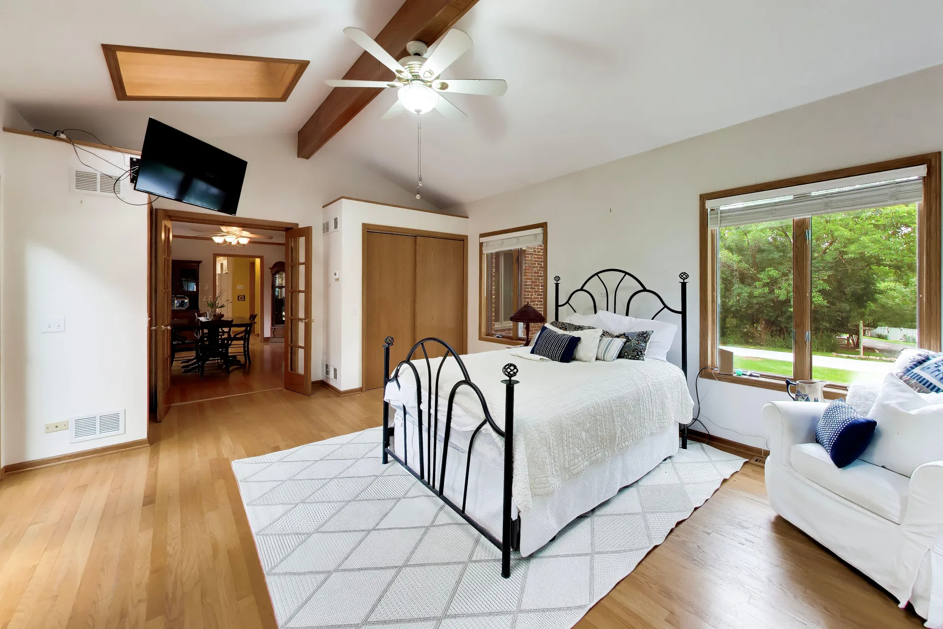 Primary bedroom with vaulted ceiling and exposed beam