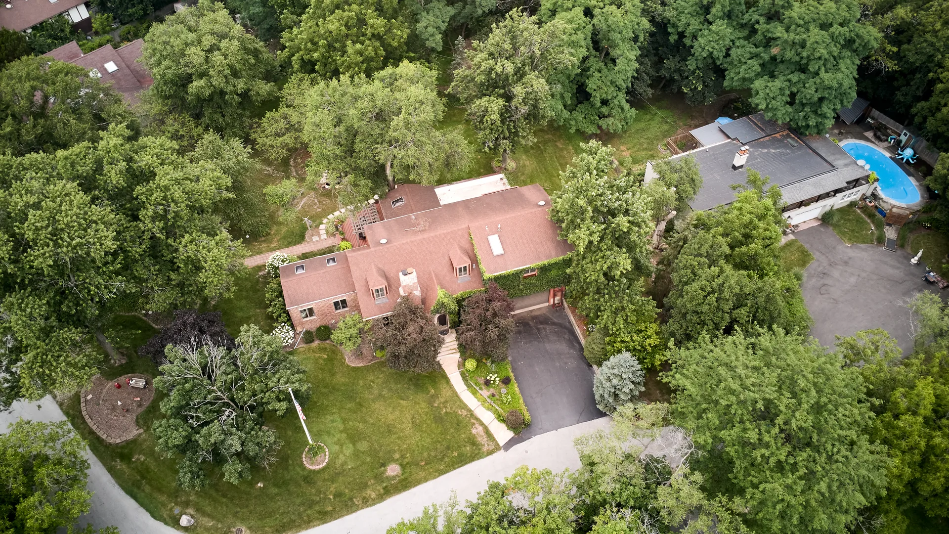Aerial view of 3708 Cooper Place showing the backyard stone pond among mature trees