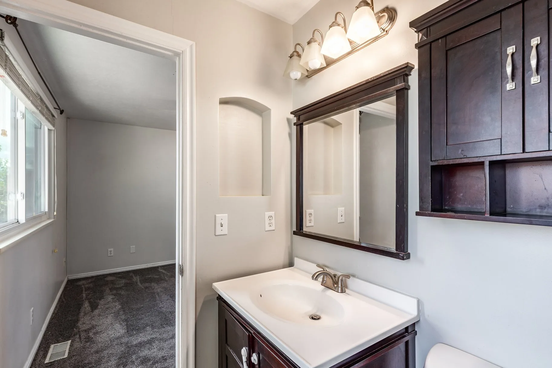 Bathroom with dark wood vanity and mirror