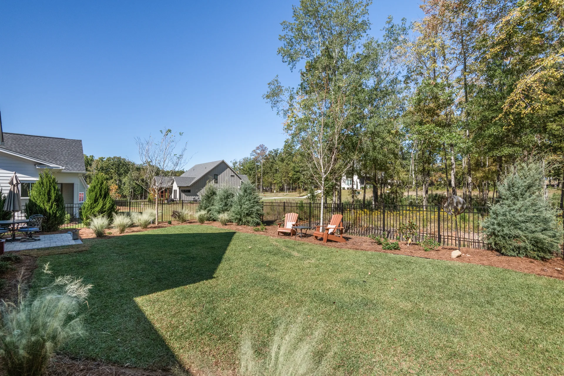 Fenced backyard with black aluminum fencing and landscaped borders