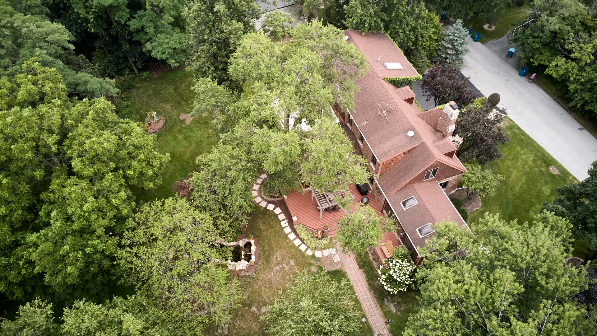 Aerial view of the deck, stone pond, and landscaped backyard