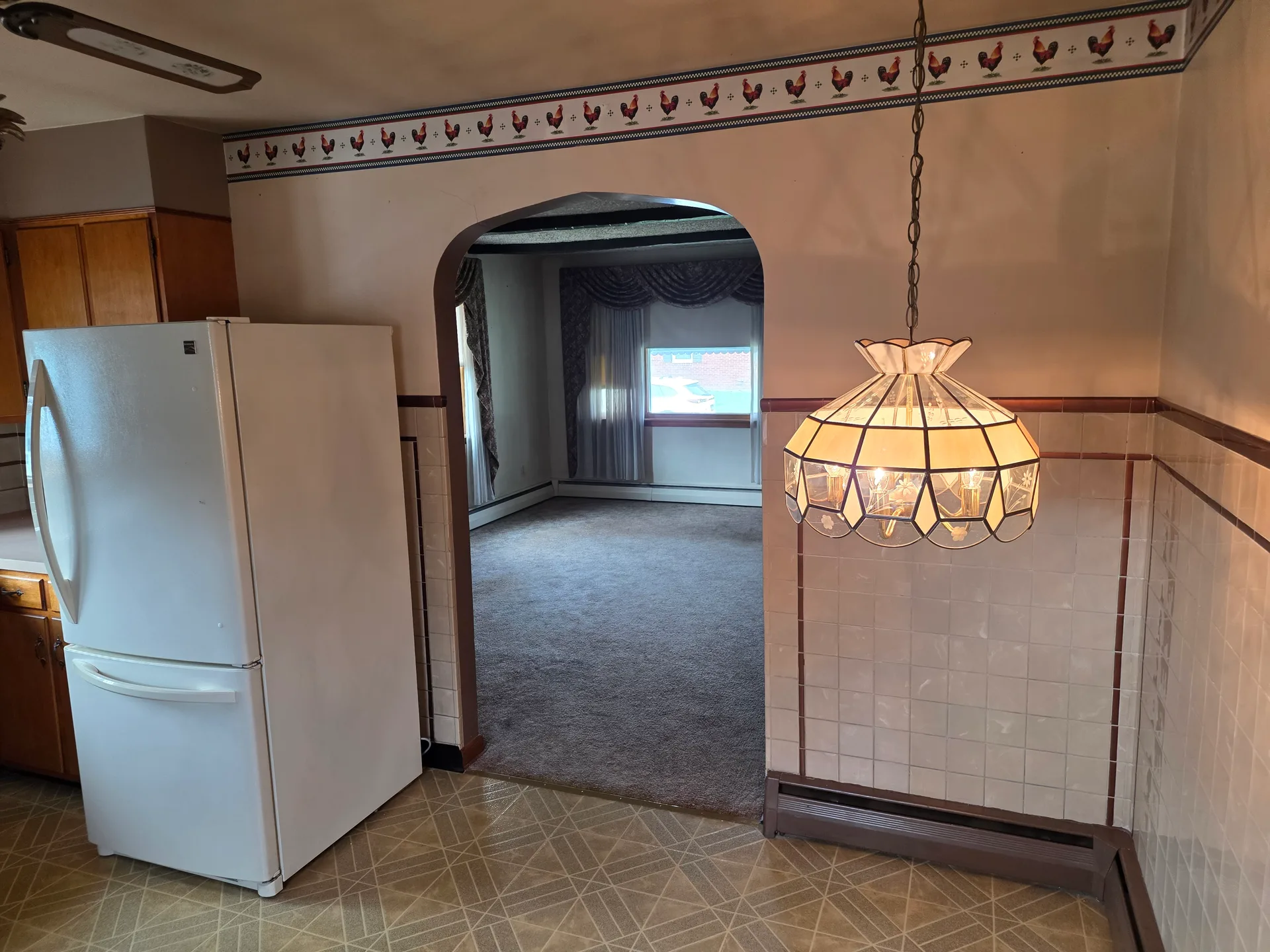 Kitchen view looking through arched doorway to living area