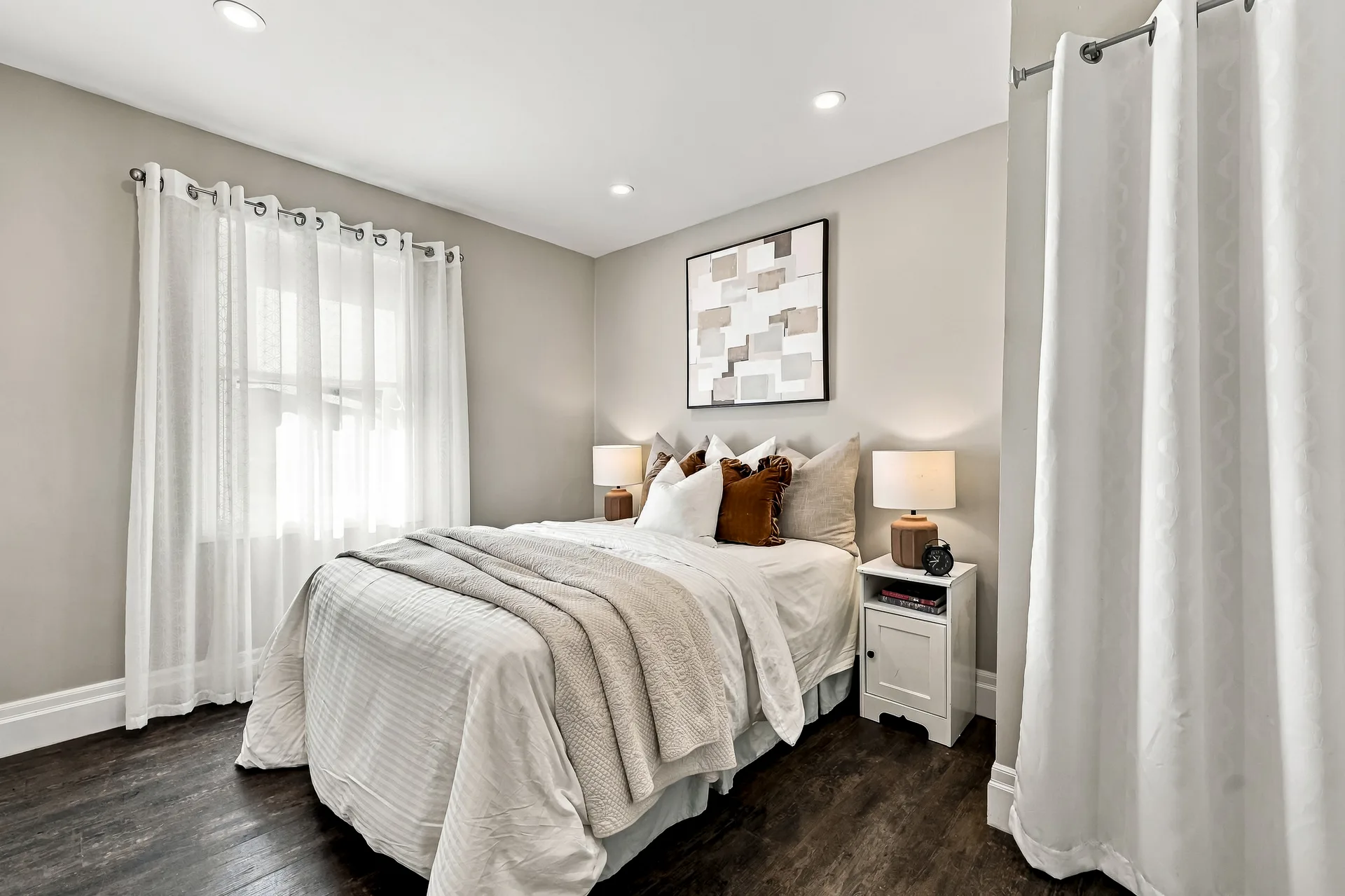 Main-floor guest bedroom with grey walls and hardwood floors